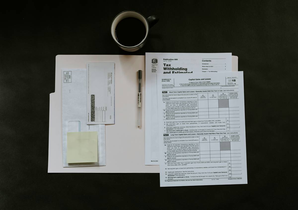 Licensing Agreements document with highlighted clauses on a desk beside a laptop